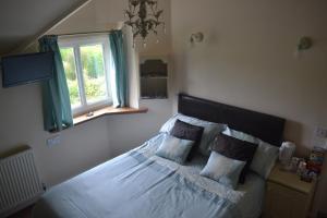 a bedroom with a bed and a window at The Lilacs in Ashbourne