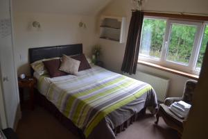 a bedroom with a bed and a window at The Lilacs in Ashbourne