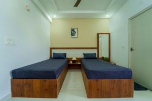 um quarto com 2 camas e um espelho em Wandr Taurus em Bangalore