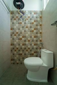 uma casa de banho com um WC e uma parede em azulejo em Wandr Taurus em Bangalore