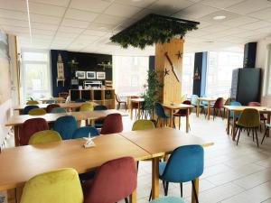 a classroom with tables and chairs and a tv at Hotel Playa de Sardiñeiro in Finisterre