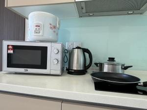 a microwave sitting on a kitchen counter with a pan on it at Leisure Home-1Bedroom in Masai