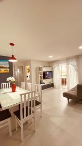 a white dining room with a table and chairs at Apartamento Familiar II - Vista para o mar e próximo ao Beto Carrero in Penha