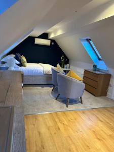 a attic room with a bed and a desk and chairs at Stunning studio flat with own large garden in Shrewsbury SLEEPS 2 in Shrewsbury