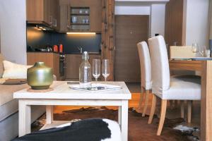 ein Wohnzimmer mit einem Tisch und Weingläsern darauf in der Unterkunft Steinberghaus Apartments in Leogang + 14 Fotos