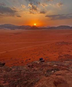 a group of people standing in the desert at sunset at Tamim Luxury Camp in Wadi Rum