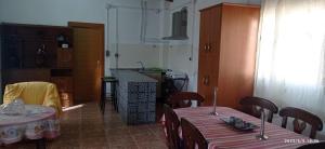 a room with two tables and a kitchen with a counter at CASA RURAL EN LA HUERTA DE MULA in Mula