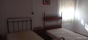 sypialnia z 2 łóżkami i oknem w obiekcie CASA RURAL EN LA HUERTA DE MULA w mieście Mula
