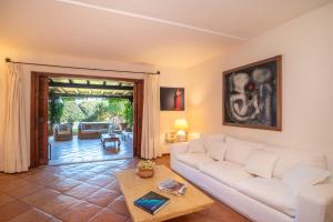 uma sala de estar com um sofá branco e uma mesa em L’aldiola - Happy Rentals em Porto Rotondo