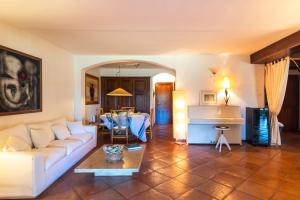 uma sala de estar com um sofá branco e uma mesa em L’aldiola - Happy Rentals em Porto Rotondo