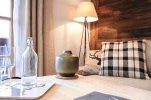 einen Tisch mit einer Glasflasche und einer Lampe darauf in der Unterkunft Steinberghaus Apartments in Leogang