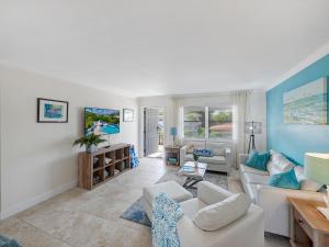 a living room with white furniture and blue walls at Bright and Sunny 2BR !!Close to Peanut Island!! in Riviera Beach
