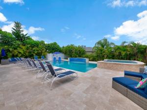 a row of lounge chairs and a swimming pool at Bright and Sunny 2BR !!Close to Peanut Island!! in Riviera Beach