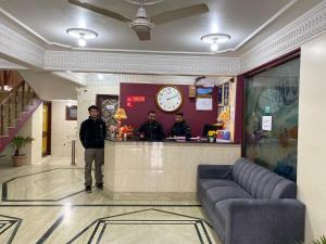 two men standing at a counter in a restaurant at Hotel City Plaza, Srinagar in Srinagar