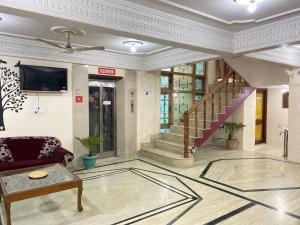 a living room with a couch and a staircase at Hotel City Plaza, Srinagar in Srinagar