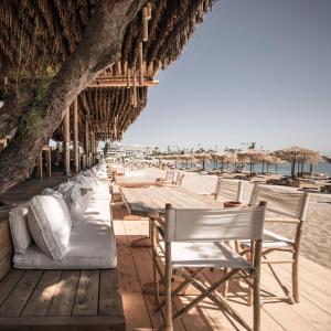 una fila de mesas y sillas en la playa en Virginia Family Resort en Kallithea Rhodes