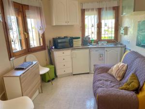 a living room with a couch and a kitchen at Estudios privados en villa con piscina privada in Els Poblets