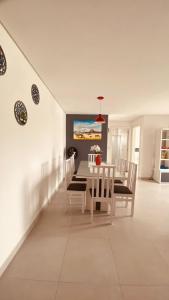 a dining room with a white table and chairs at Apartamento Familiar II - Vista para o mar e próximo ao Beto Carrero in Penha