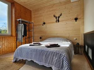 a bedroom with a bed in a wooden wall at Appartement Chaleureux Gérardmer proche forêt in Gérardmer
