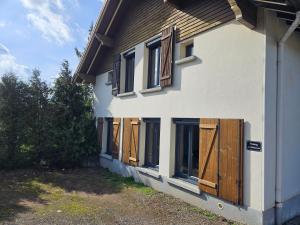 a house with wooden doors on the side of it at Appartement Chaleureux Gérardmer proche forêt in Gérardmer