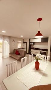 a kitchen and living room with a table and chairs at Apartamento Familiar II - Vista para o mar e próximo ao Beto Carrero in Penha