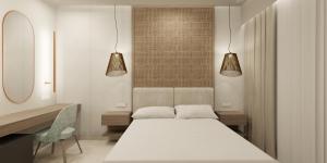 a room with a bed and a desk and two lights at Colonides Beach Hotel in Vounaria