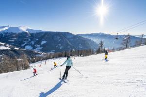 un grupo de personas esquiando por una pista cubierta de nieve en Apartment Aleks, en Bach