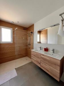 a bathroom with a sink and a glass shower at L'Eden des Aspres in Thuir