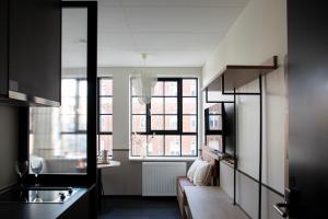 a kitchen with a couch and a window in a room at Bob W Copenhagen Østerbro in Copenhagen