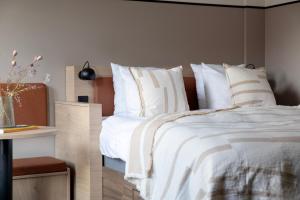a bedroom with a bed with white sheets and pillows at Bob W Copenhagen Østerbro in Copenhagen