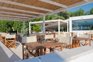 un patio al aire libre con mesas y sillas de madera en Baia di Gallipoli Camping Village, en Gallipoli