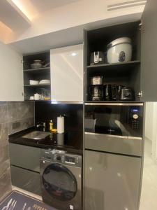 a kitchen with a stove and a dishwasher at Kass Towers, Studio Apartment in Accra