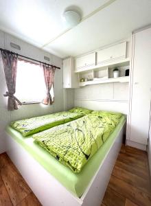 Łóżko w małym pokoju z oknem w obiekcie Mobilheim Josefína - Výrovická přehrada w mieście Výrovice