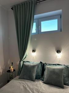 1 dormitorio con 1 cama con 2 almohadas y ventana en VISTA Apartment en Mińsk Mazowiecki