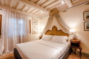 ein Schlafzimmer mit einem weißen Bett und einem Fenster in der Unterkunft Equo Suites in Petrignano sul Lago