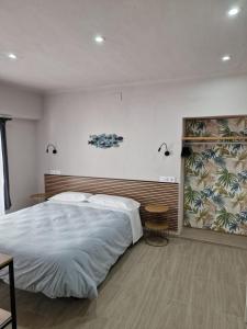 een slaapkamer met een groot bed en een groot raam bij Pensió i Apartament Torrent in L'Escala