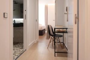 ein Zimmer mit einem Tisch und ein Schlafzimmer mit einem Bett in der Unterkunft Woohoo Rooms Boutique Luna in Madrid