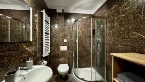 a bathroom with a shower and a sink and a toilet at Mala Italia Apartments in Wrocław