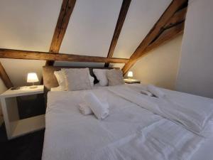 duże łóżko z białą pościelą i poduszkami w obiekcie SiOUX: luxuriöse Penthousewohnung im Stadtzentrum w mieście Kempten