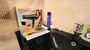a bathroom counter with a sink with a hair dryer and a mixer at High Rise Executive Apartments Facing Centaurus Mall Islamabad in Islamabad