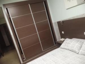 Una puerta corredera de cristal en un dormitorio con cama en Nuñez Tomelloso, en Tomelloso