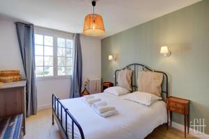 ein Schlafzimmer mit einem großen Bett mit Handtüchern darauf in der Unterkunft L'élégante/Belle Villa Familiale in Saint-Avertin