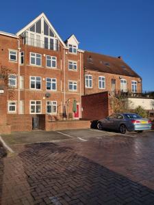a car parked in front of a brick building at Birmingham City Apartment - Spacious & Fully Serviced with Secure Parking in Birmingham