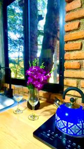 - une table avec deux verres, un pot et des fleurs dans l'établissement Cabaña Hermosa Bosque Fraccionamiento Privado, à Mineral del Chico