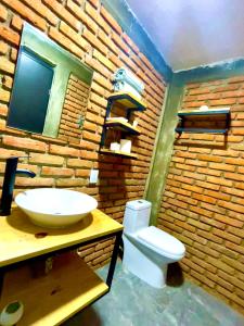 uma casa de banho com um lavatório, um WC e uma parede de tijolos. em Cabaña Hermosa Bosque Fraccionamiento Privado em Mineral del Chico