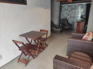 uma mesa e cadeiras numa sala de estar com uma mesa em Vitória Suítes - Vila de São Jorge em São Jorge