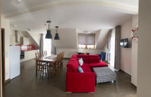 uma sala de estar com um sofá vermelho e uma mesa em Faro Resort em Mrzeżyno