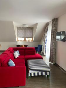 a living room with a red couch and a table at Faro Resort in Mrzeżyno