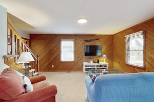 uma sala de estar com um sofá azul e uma televisão em Seaclusion em Frisco