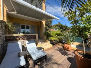 une terrasse d'une maison avec une table et des chaises dans l'établissement T2 vue mer avec jardinet / plage et port à pied, à Sanary-sur-Mer